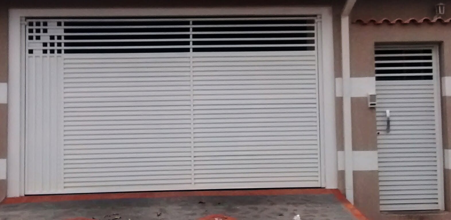 Portão com friso vazado e porta social integrada